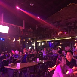 บรรยากาศภายในร้านจันทร์เสวย โกดัง1 มุมกว้างเห็นเวทีและผู้คน
